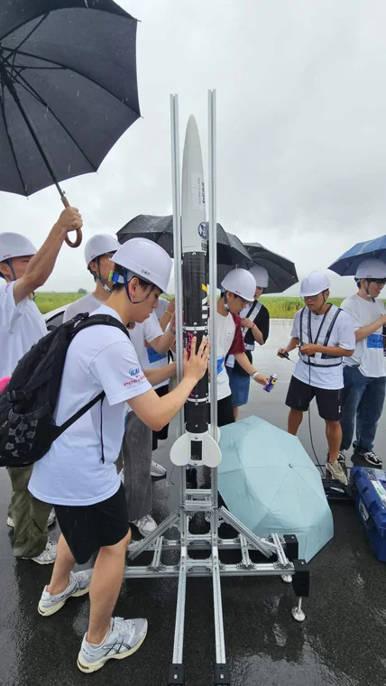 The PSI team placing the vehicle on the launch rail and preparing at the field.