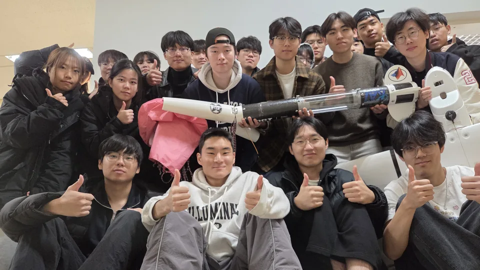 Members with the rocket and its parachute.